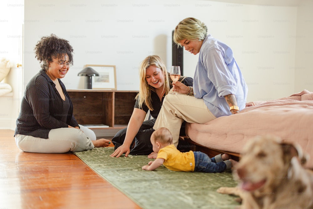 three women and a baby sitting on the floor