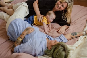 a woman and a baby laying on a bed