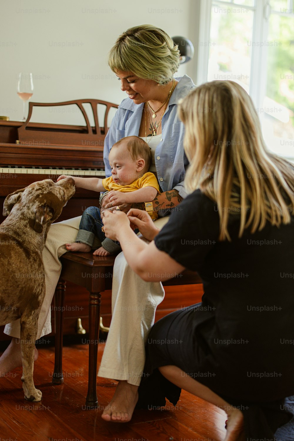 a woman sitting on a chair with a baby and a dog