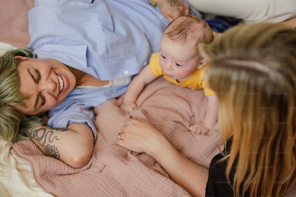 a woman laying on a bed holding a baby