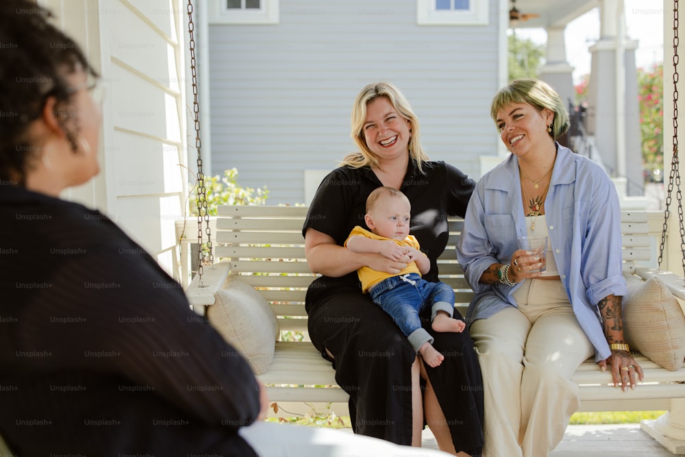 a woman sitting on a porch swing holding a baby