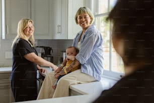 two women and a baby in a kitchen
