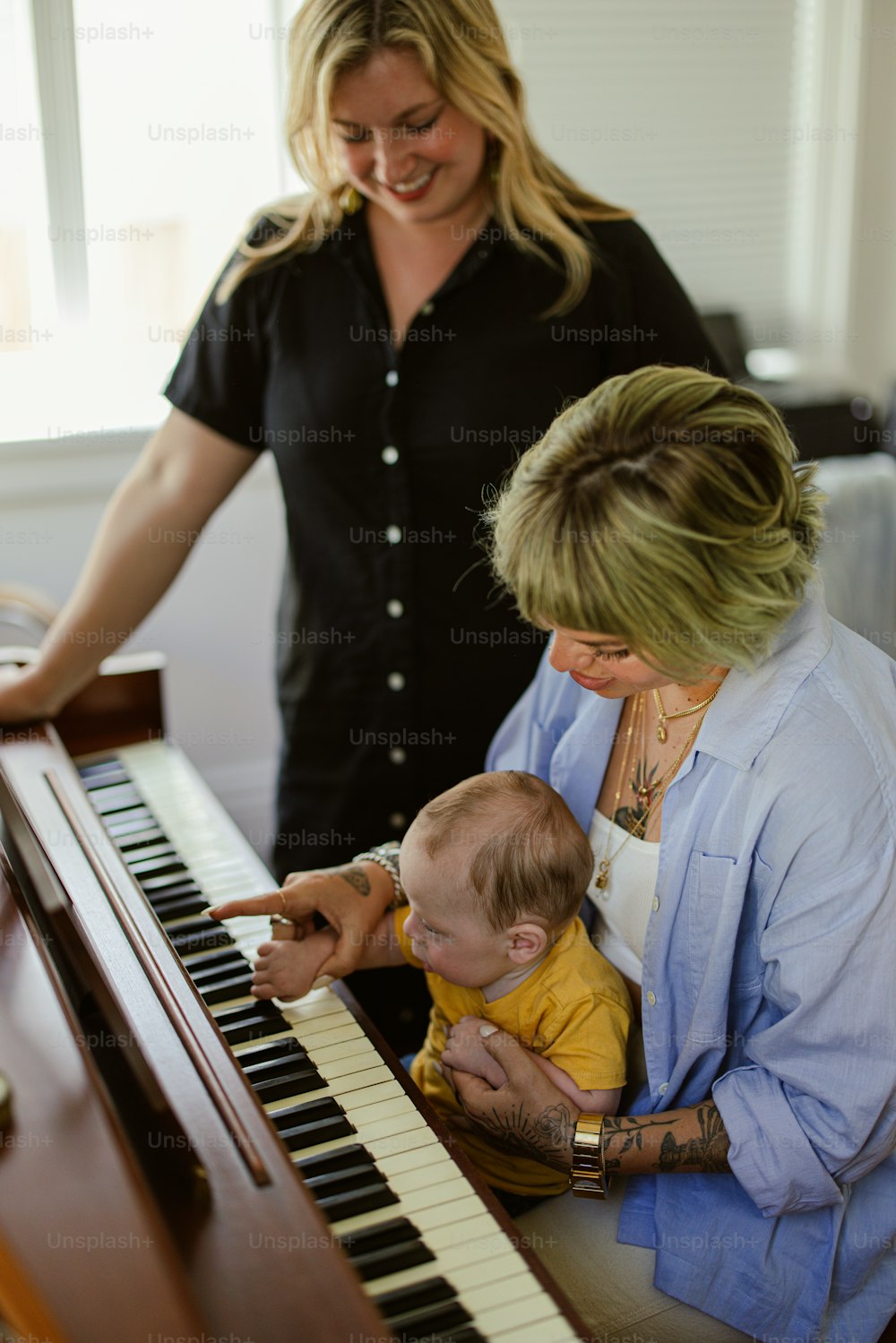 a woman is playing a piano with a baby