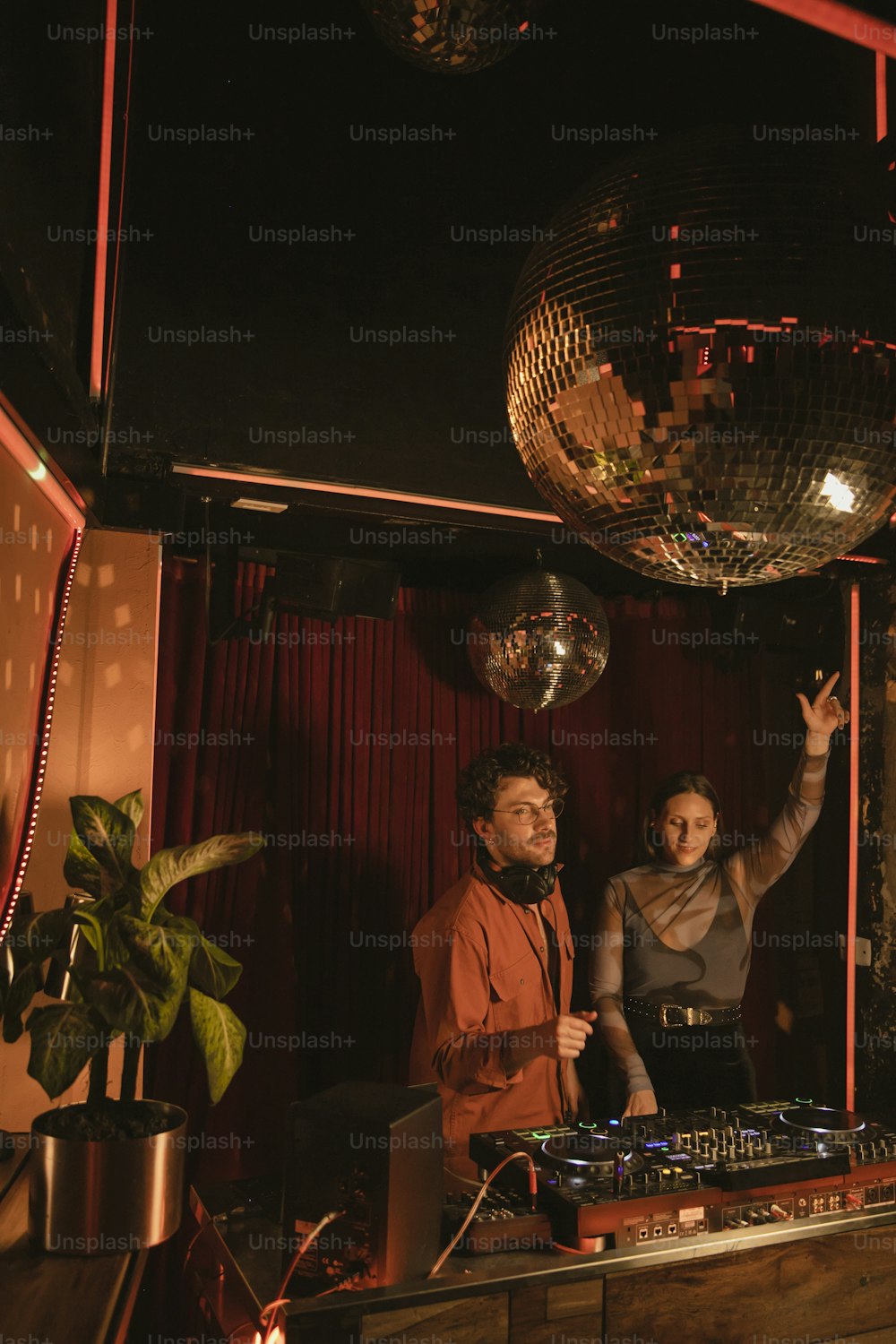 Un hombre y una mujer parados frente a una bola de discoteca