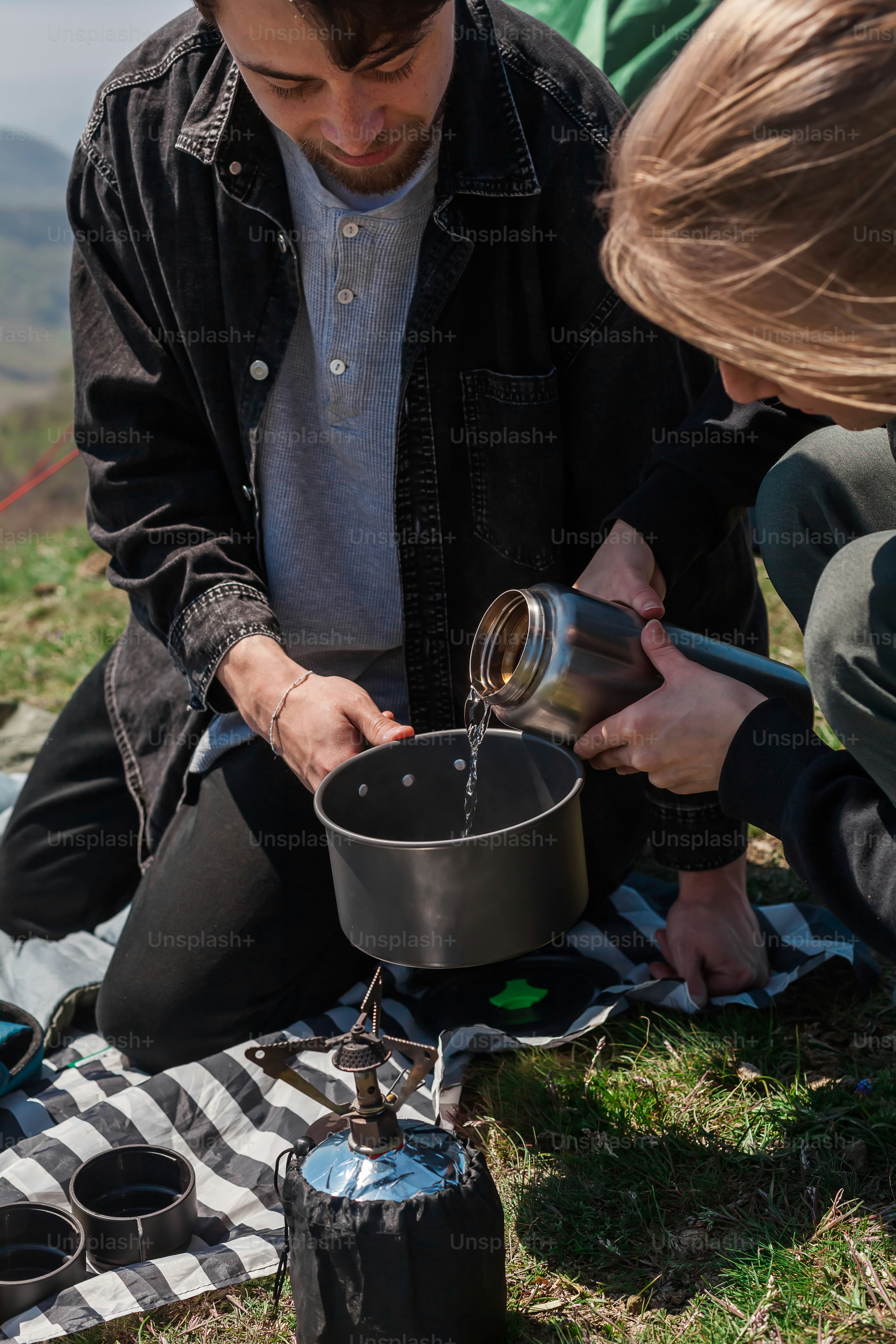 a man pouring water into a pot on top of a stove