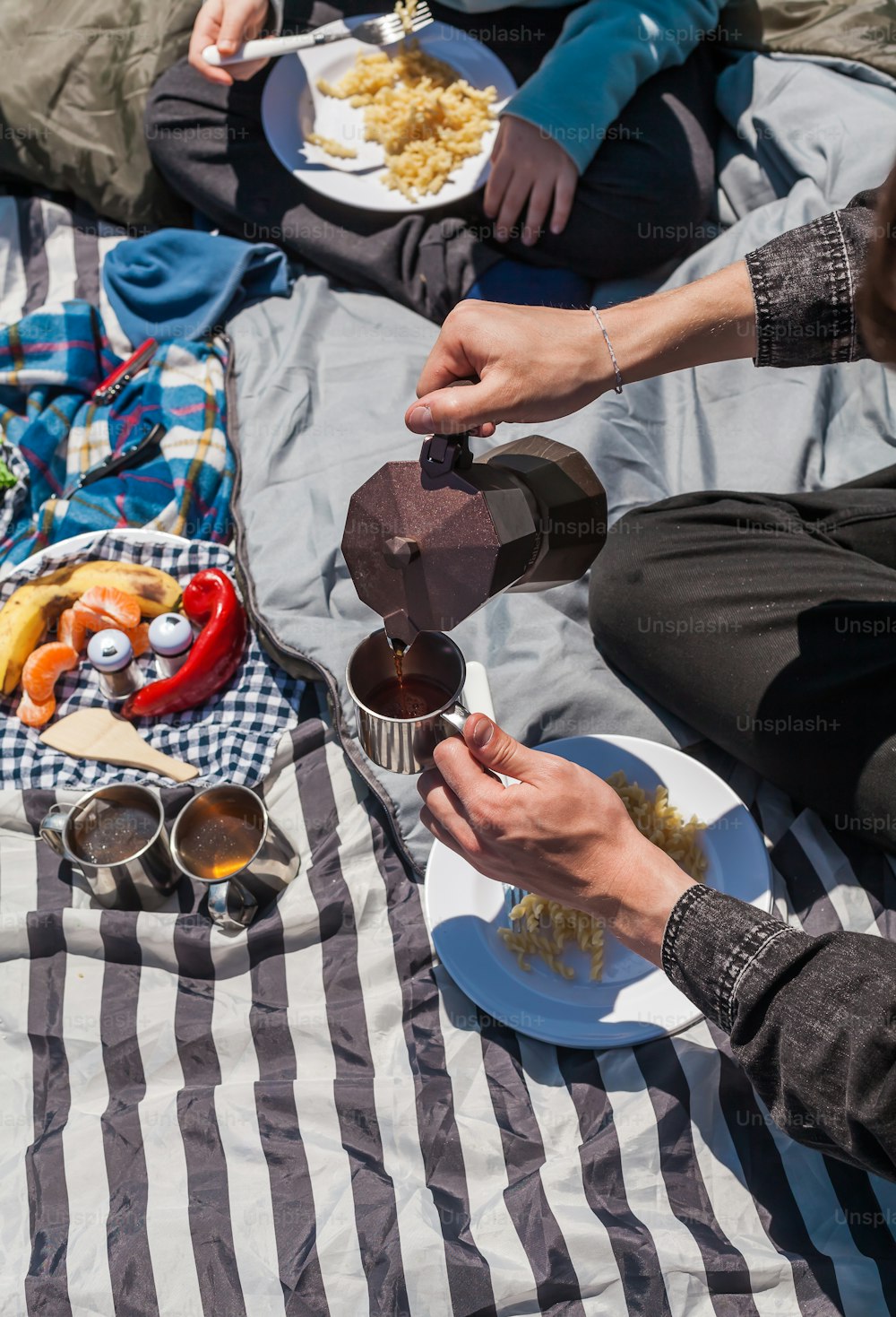 a couple of people sitting on top of a blanket