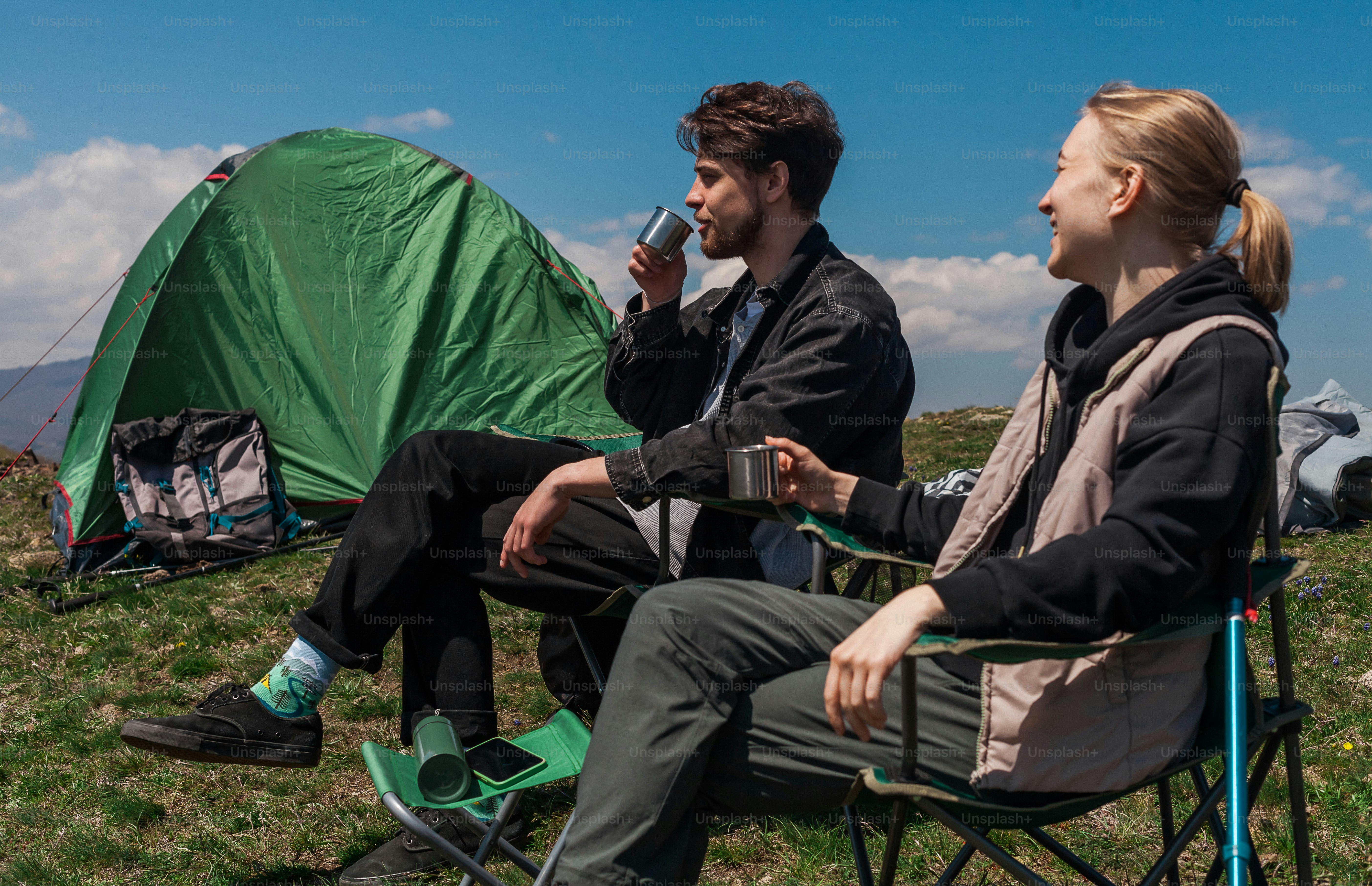 a man and a woman sitting next to a tent