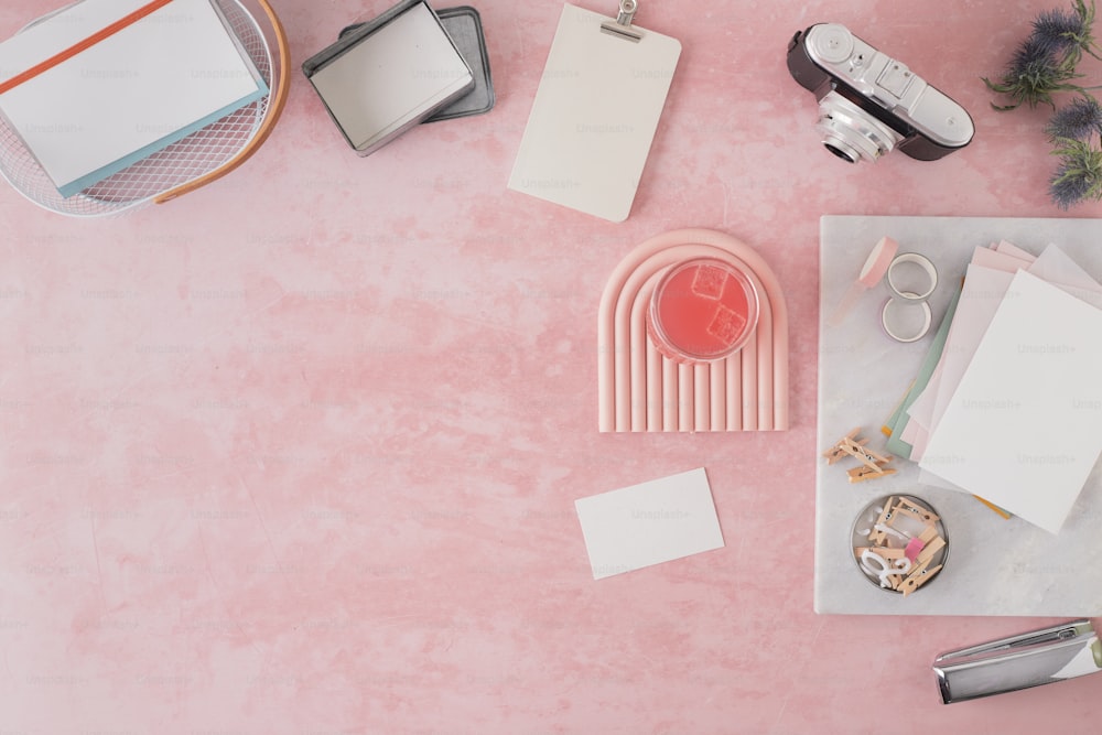 uma mesa rosa coberta com muitos materiais de escritório