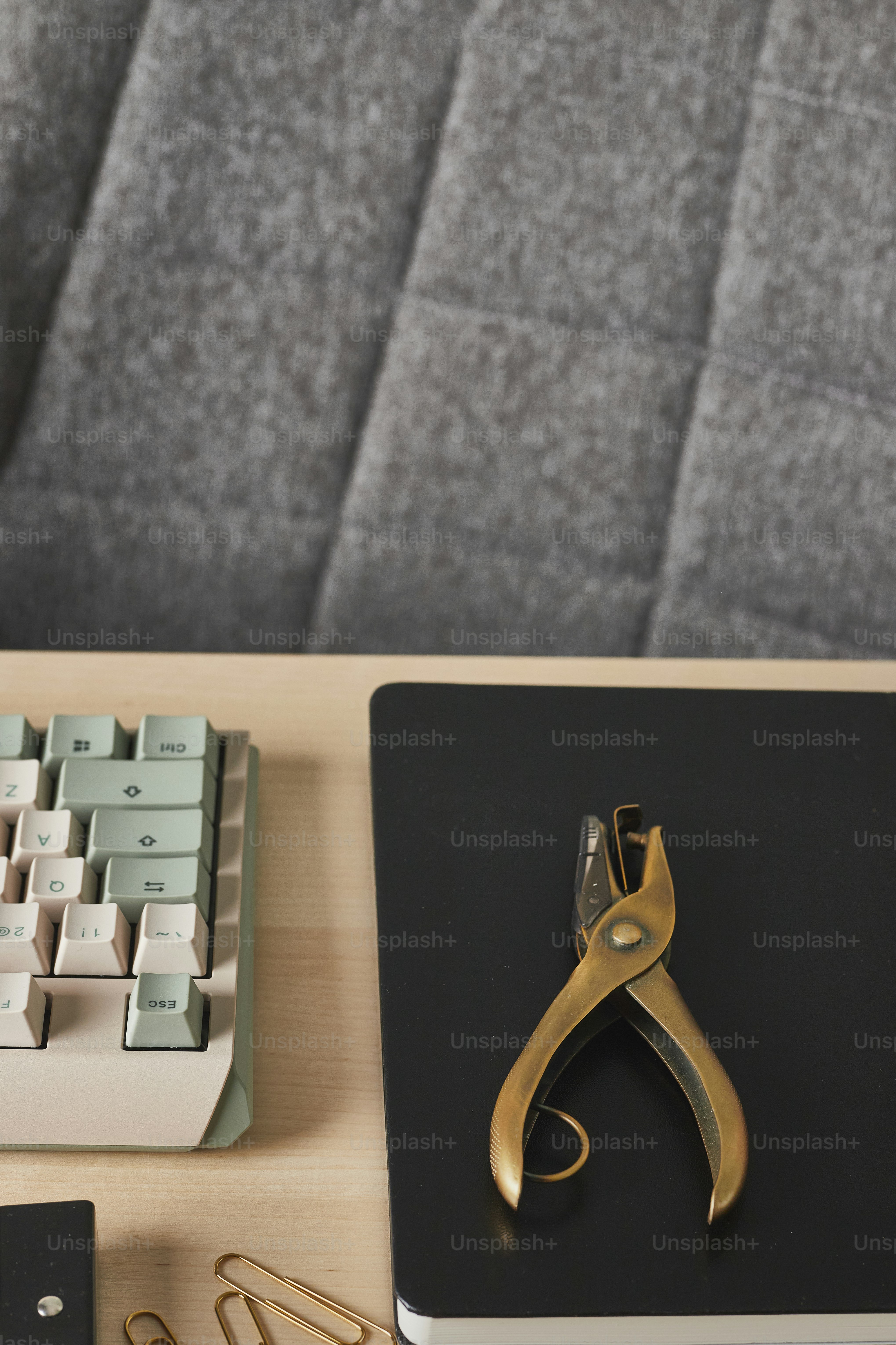 a desk with a laptop, keyboard and a pair of scissors