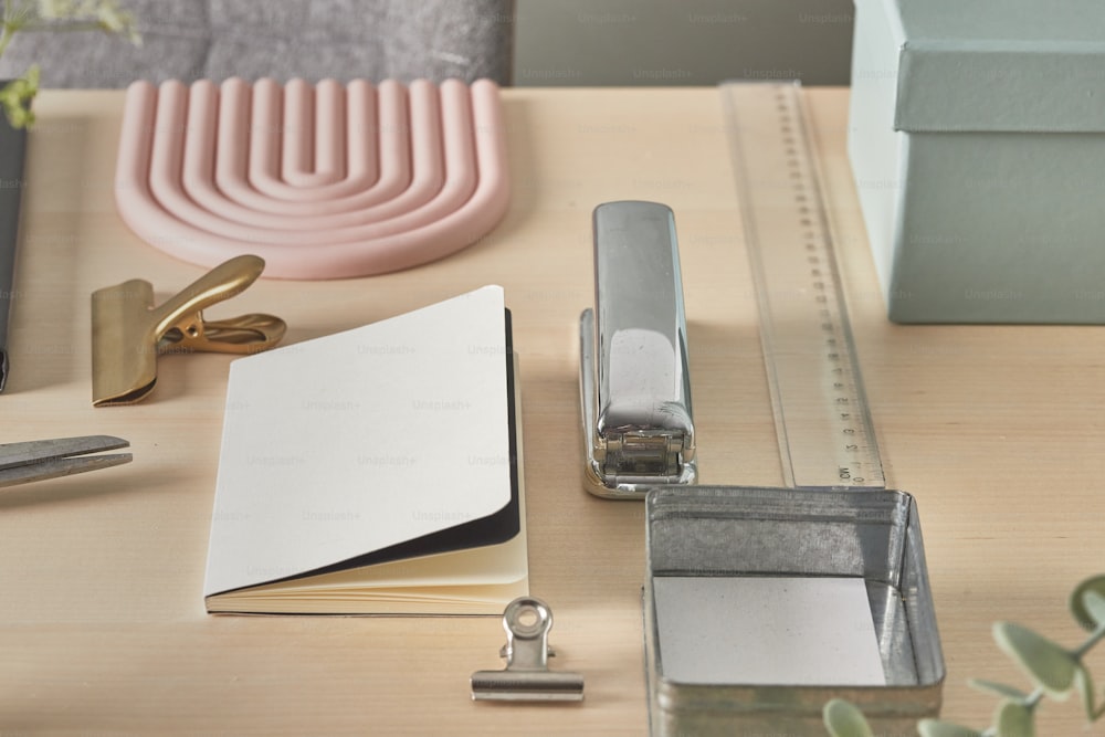 un escritorio con una carpeta, bolígrafo, tijeras y otros suministros de oficina