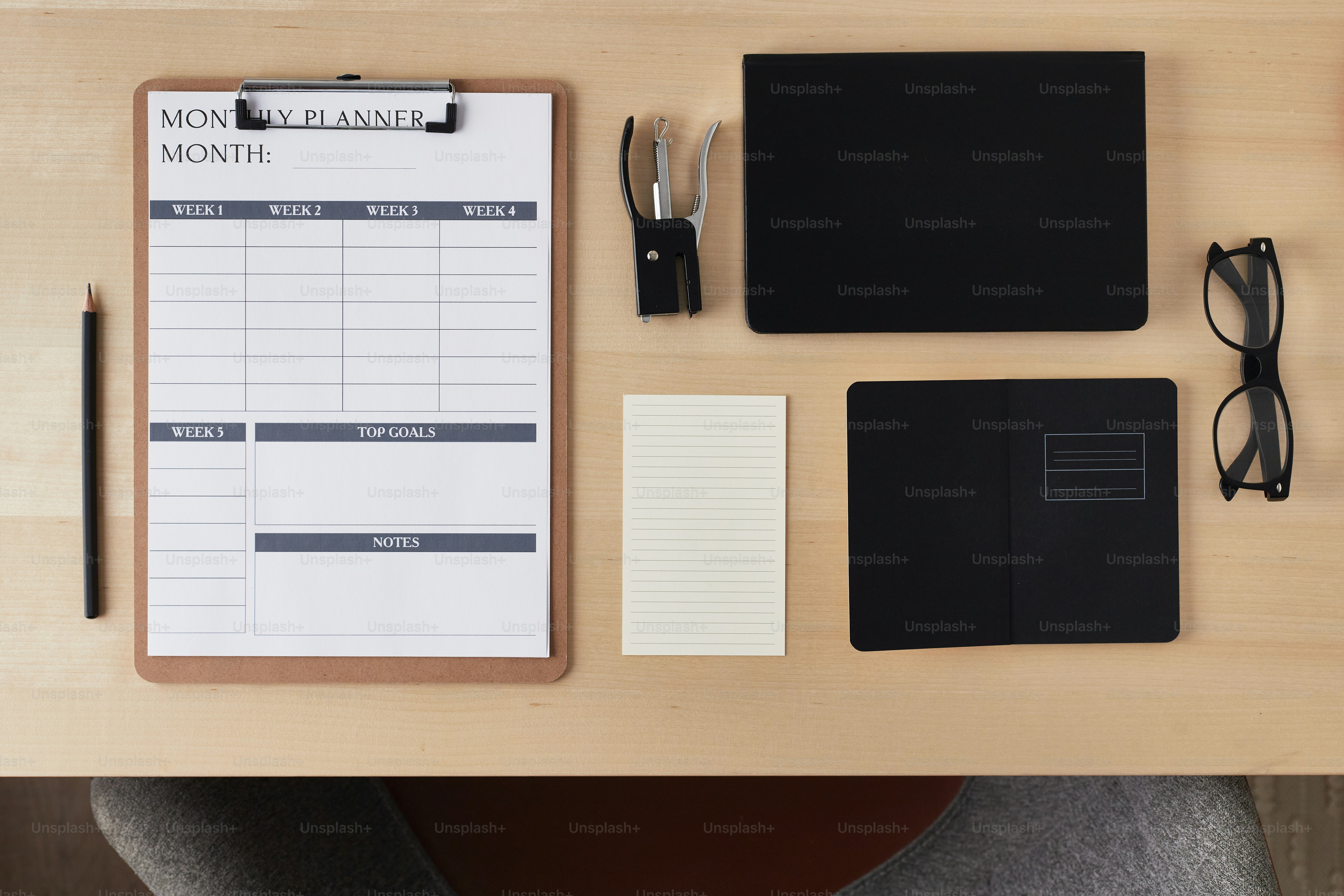 a desk with a notepad, pen, glasses, eyeglasses, and