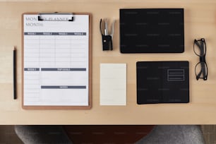 a desk with a notepad, pen, glasses, eyeglasses, and