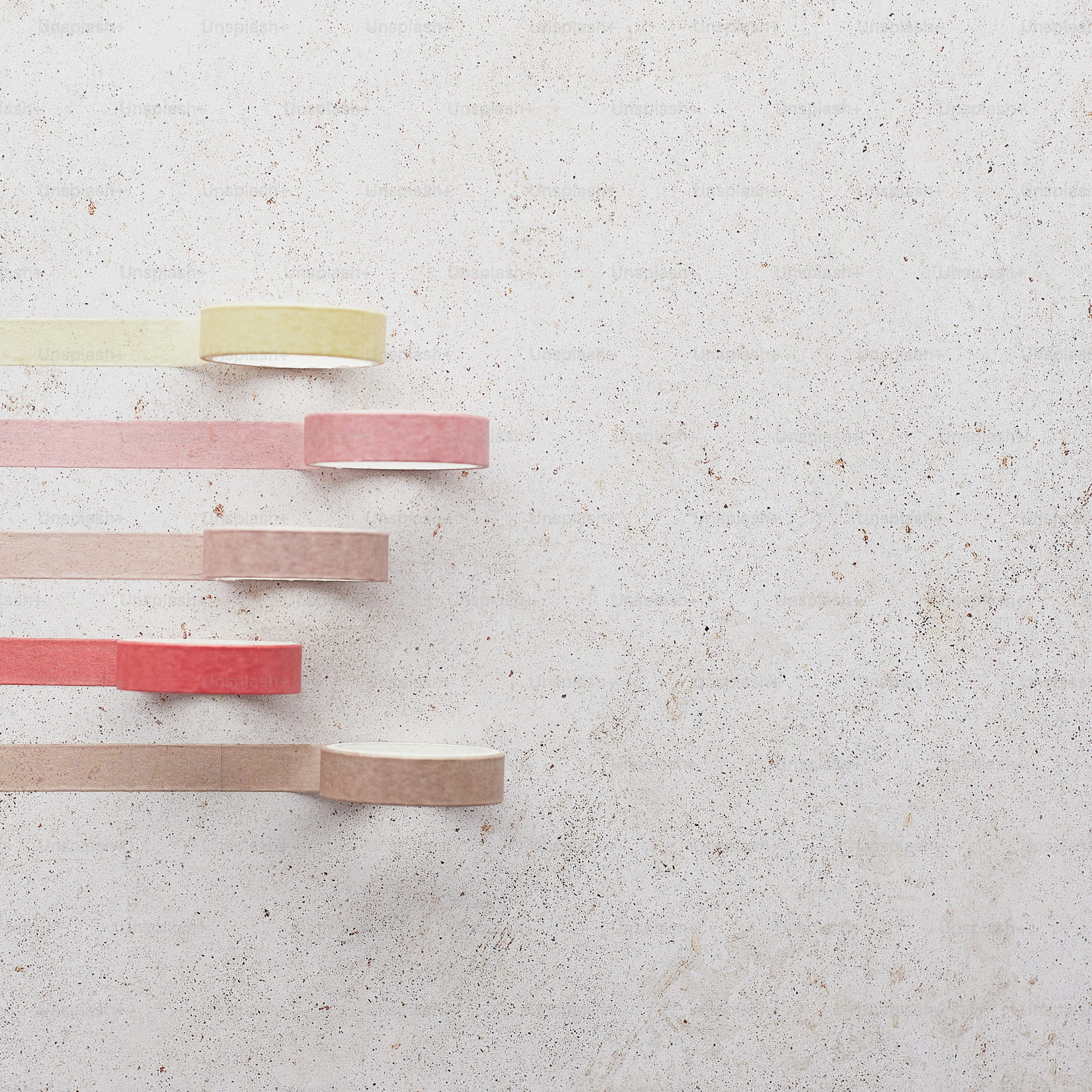 un gruppo di bastoni di legno seduti in cima a un muro bianco