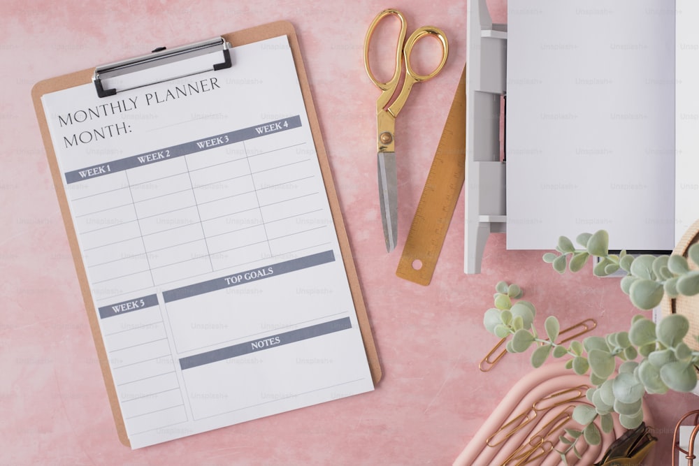 a clipboard with a daily planner next to a pair of scissors