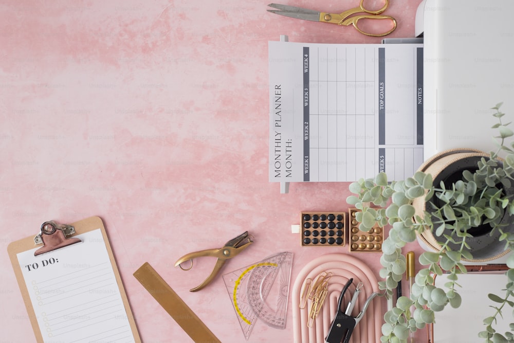 a pink desk with a clipboard and a plant