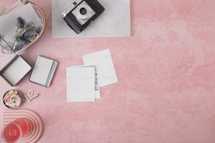 a pink table with a camera and other items on it