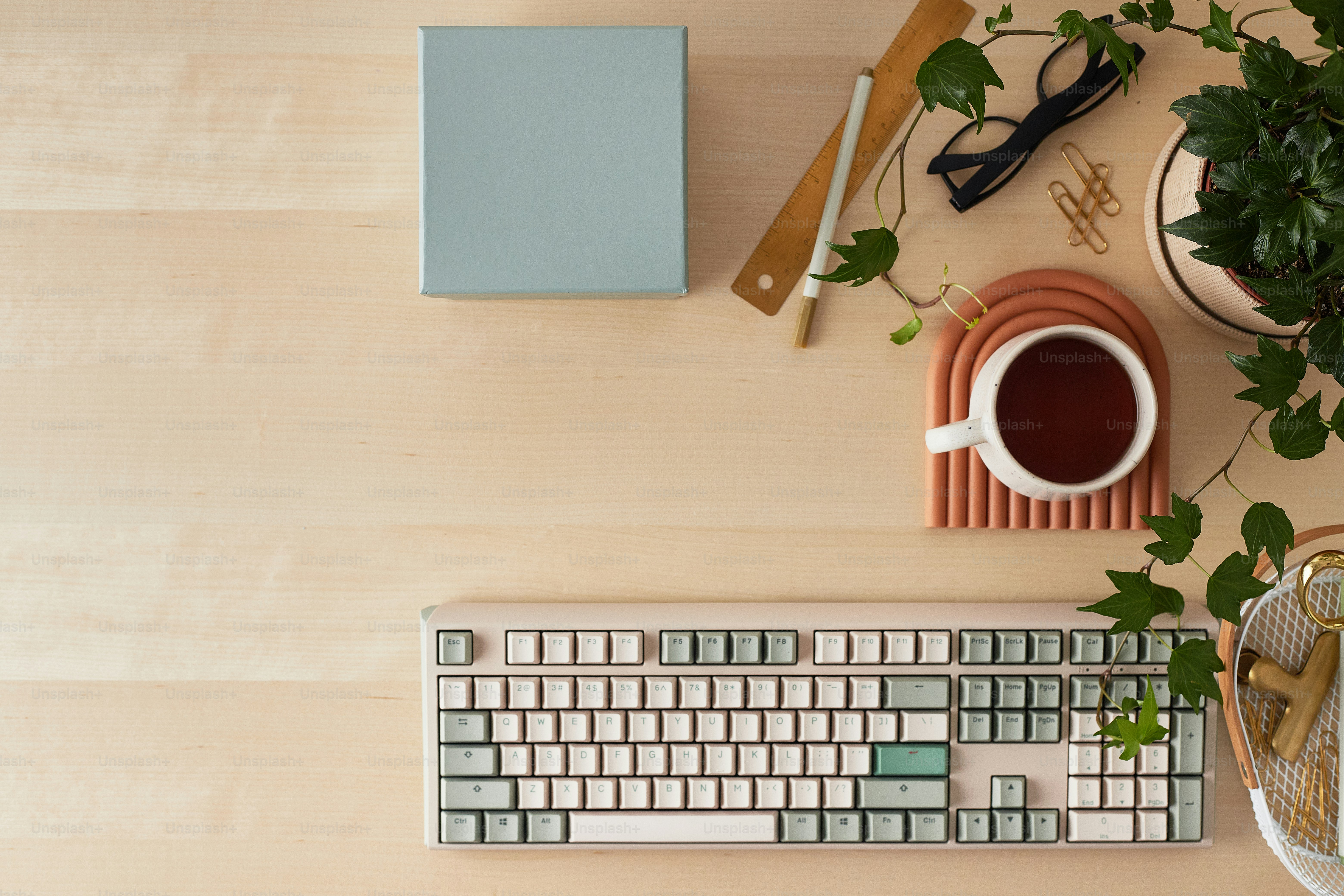 desk with mechanical keyboard,plant, tea,and desk essentials