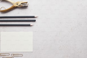 um par de tesouras, lápis e um bloco de notas sobre uma mesa