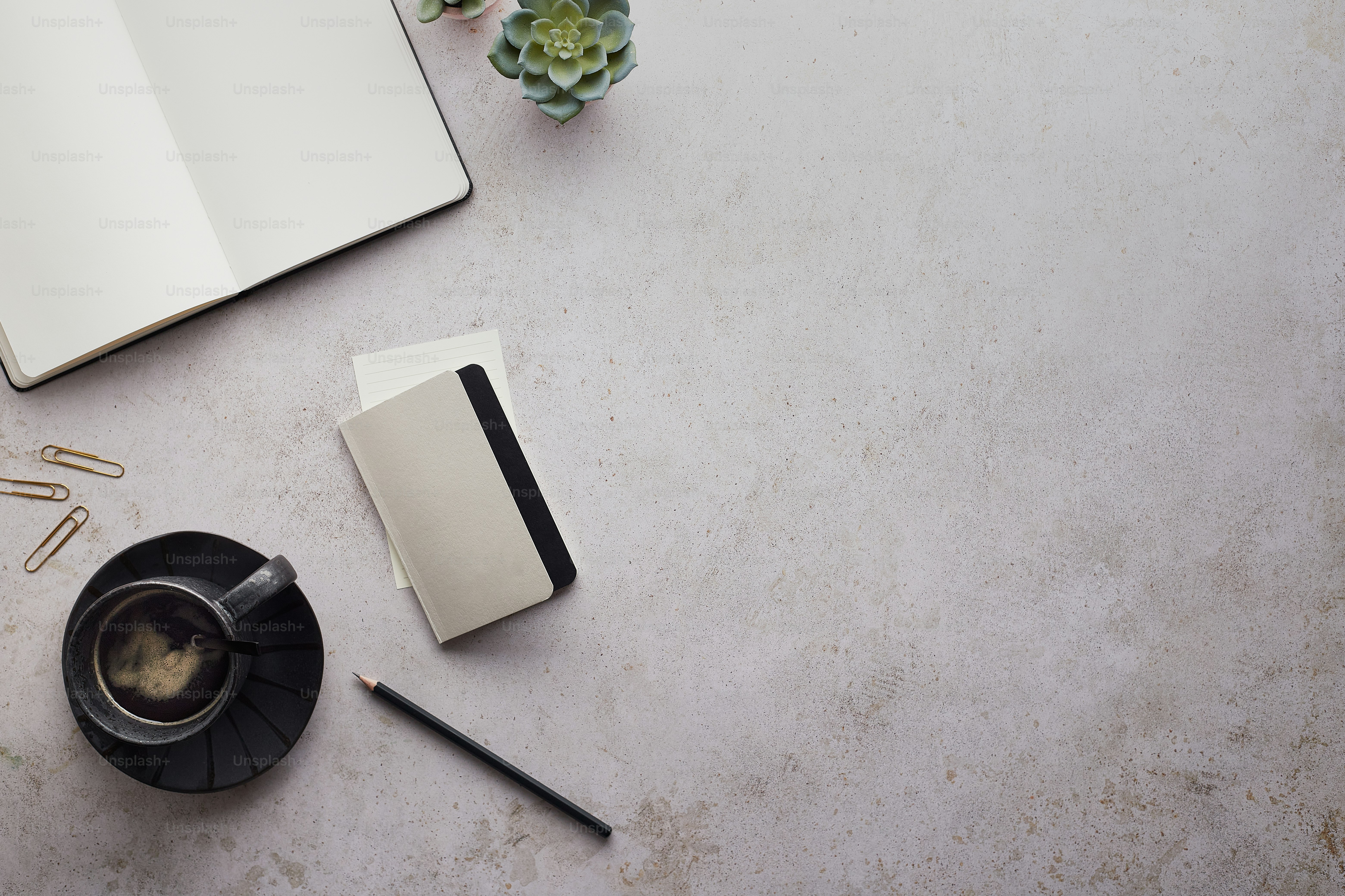 a cup of coffee and a notebook on a table