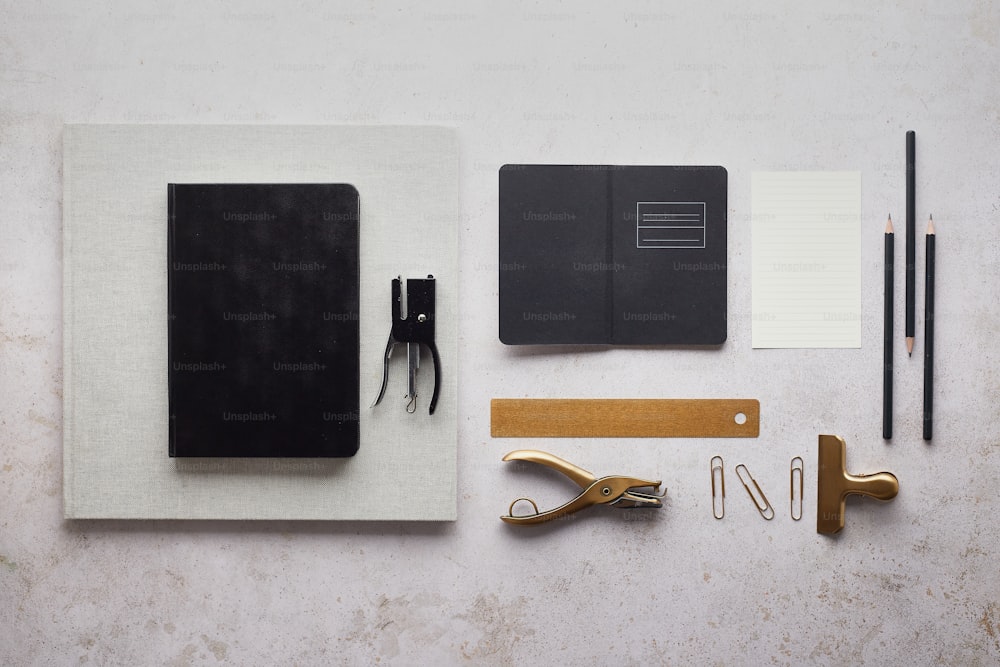 a notepad, pen, scissors, notebook, and other items laid out on