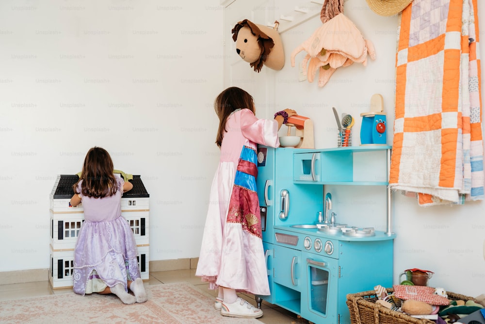 duas meninas brincando em uma cozinha de brincar