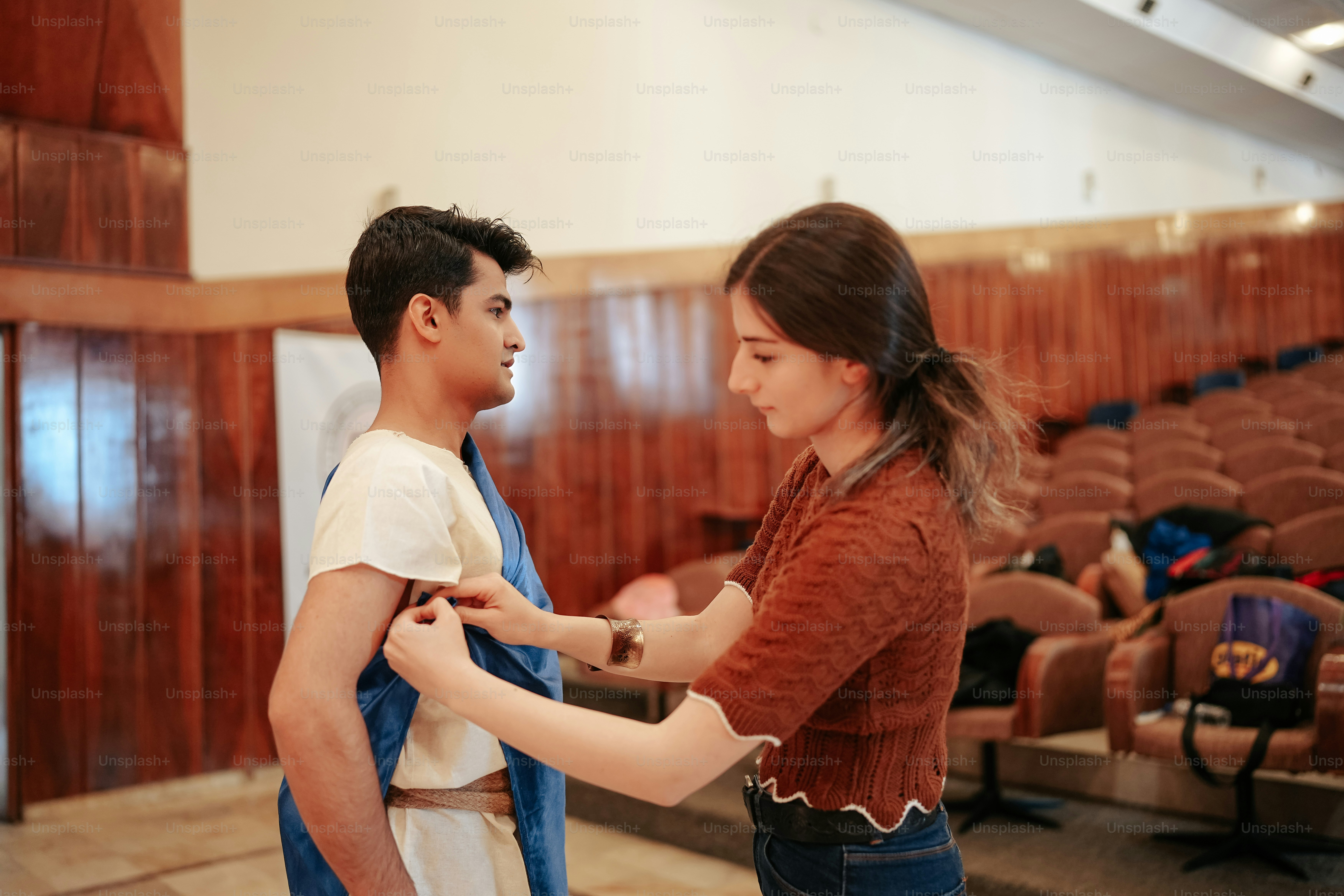 a woman helping a man put on his tie