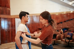 a woman helping a man put on his tie