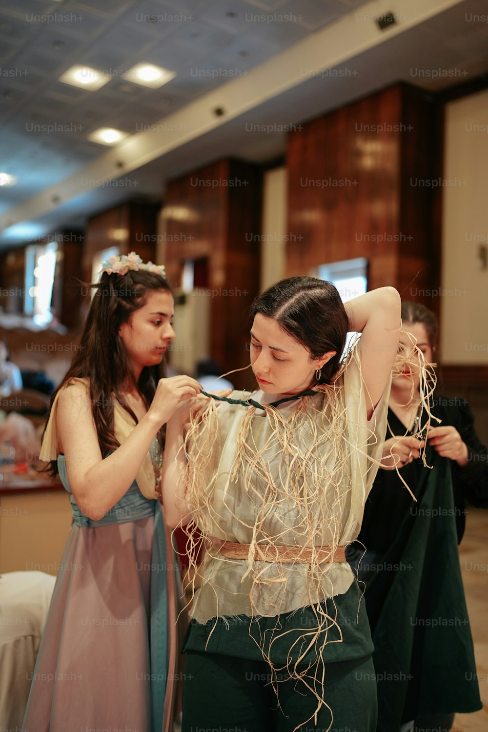 a woman is helping another woman with her hair