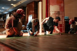 a group of people kneeling down on a wooden floor