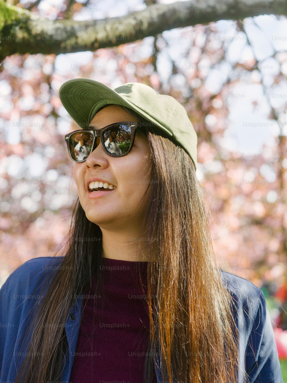 a woman wearing a green hat and sunglasses