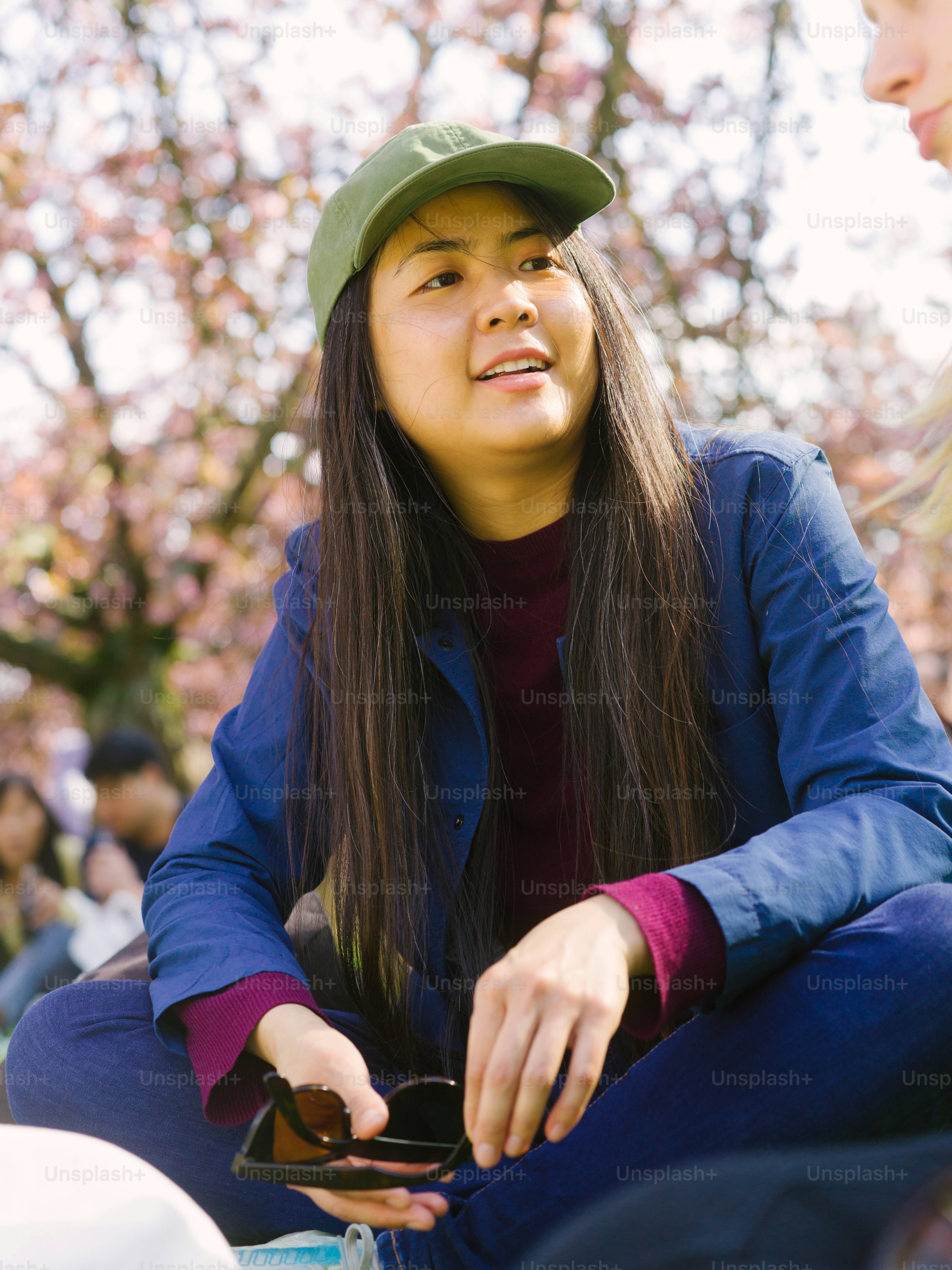 a woman sitting on the ground with a cell phone