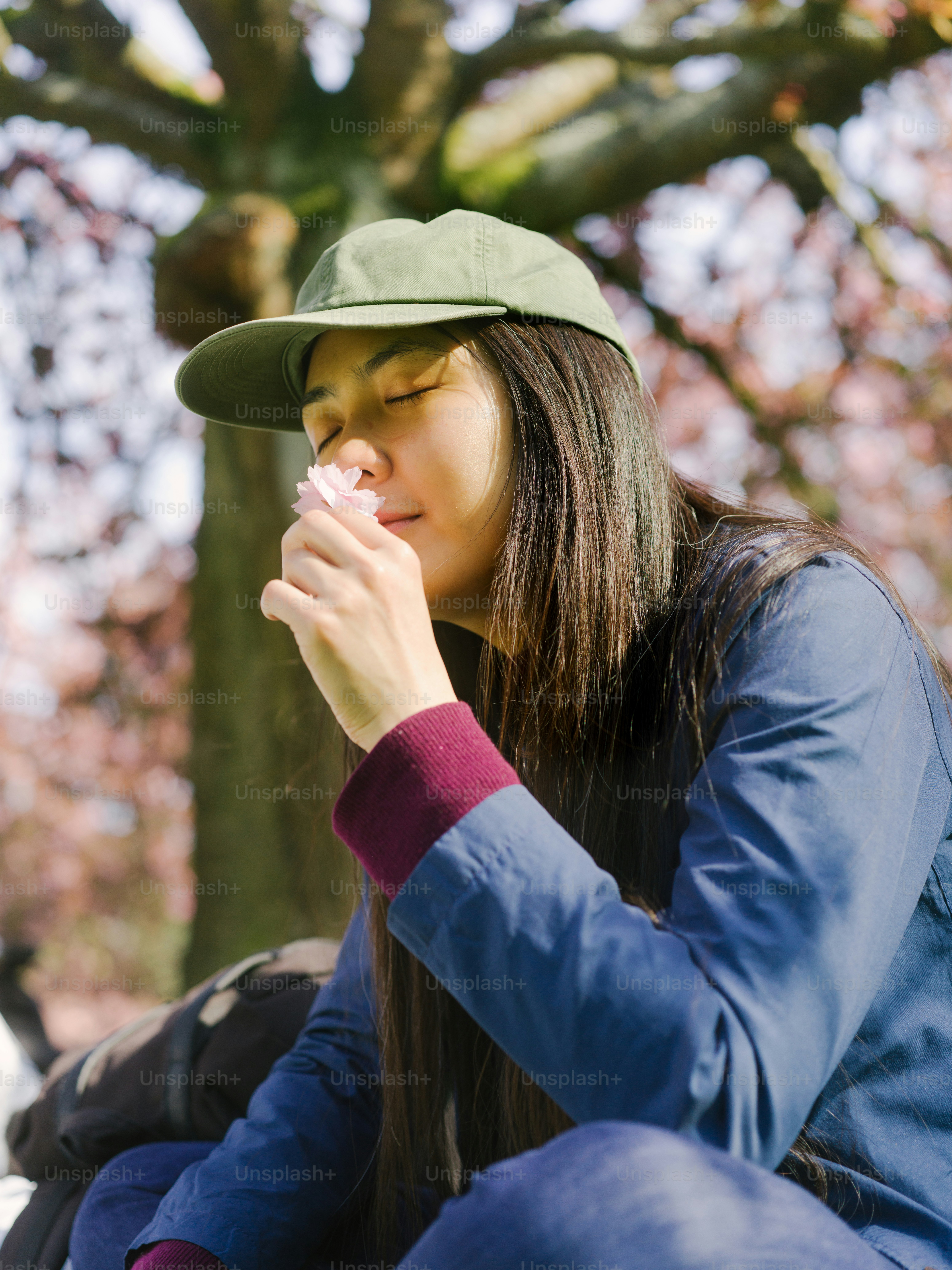 a woman sitting on the ground blowing her nose