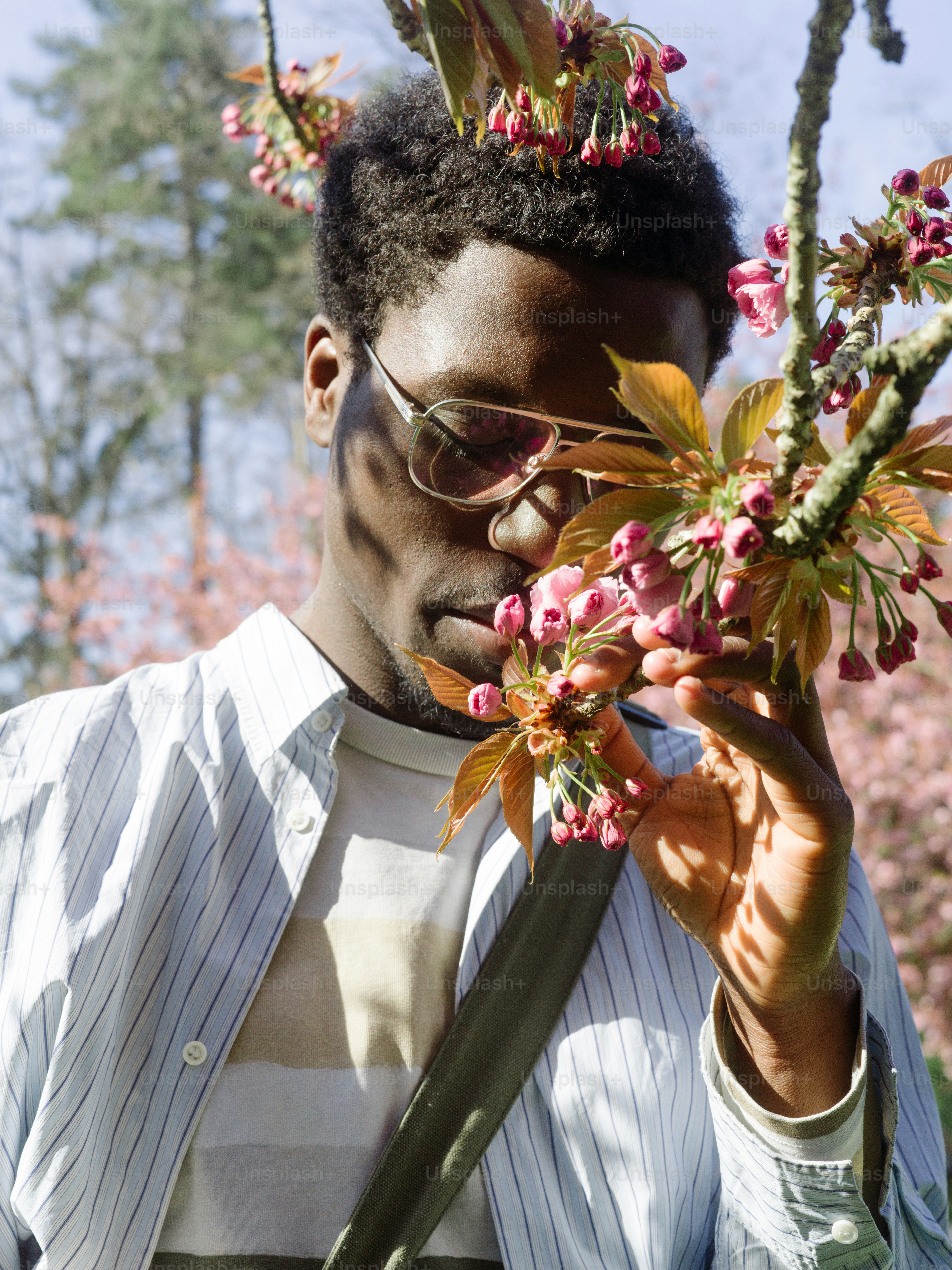 a man holding a bunch of flowers in front of his face