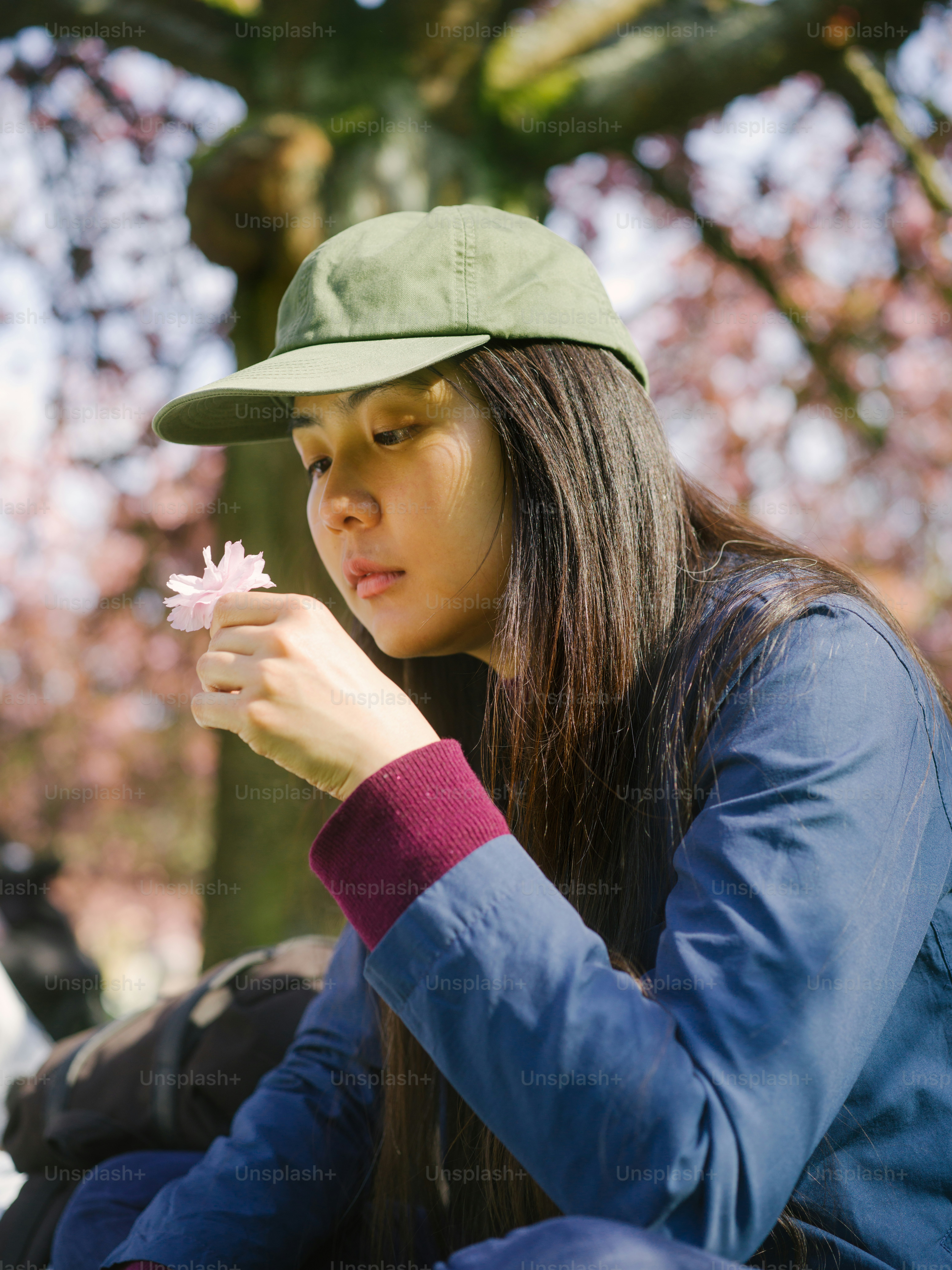 a woman sitting on the ground with a flower in her hand
