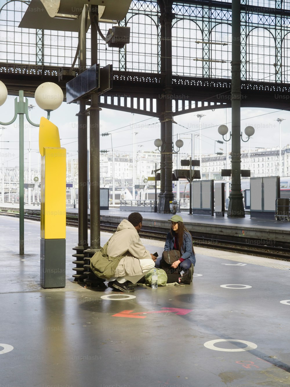 two people sitting on a bench in a train station