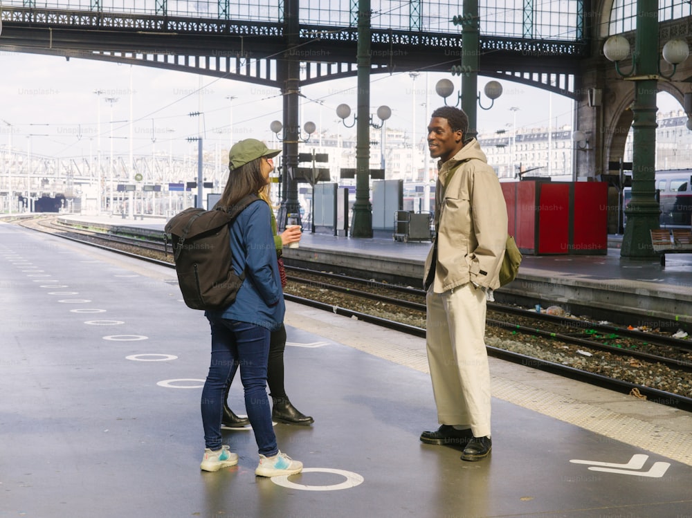a man and a woman standing on a train platform