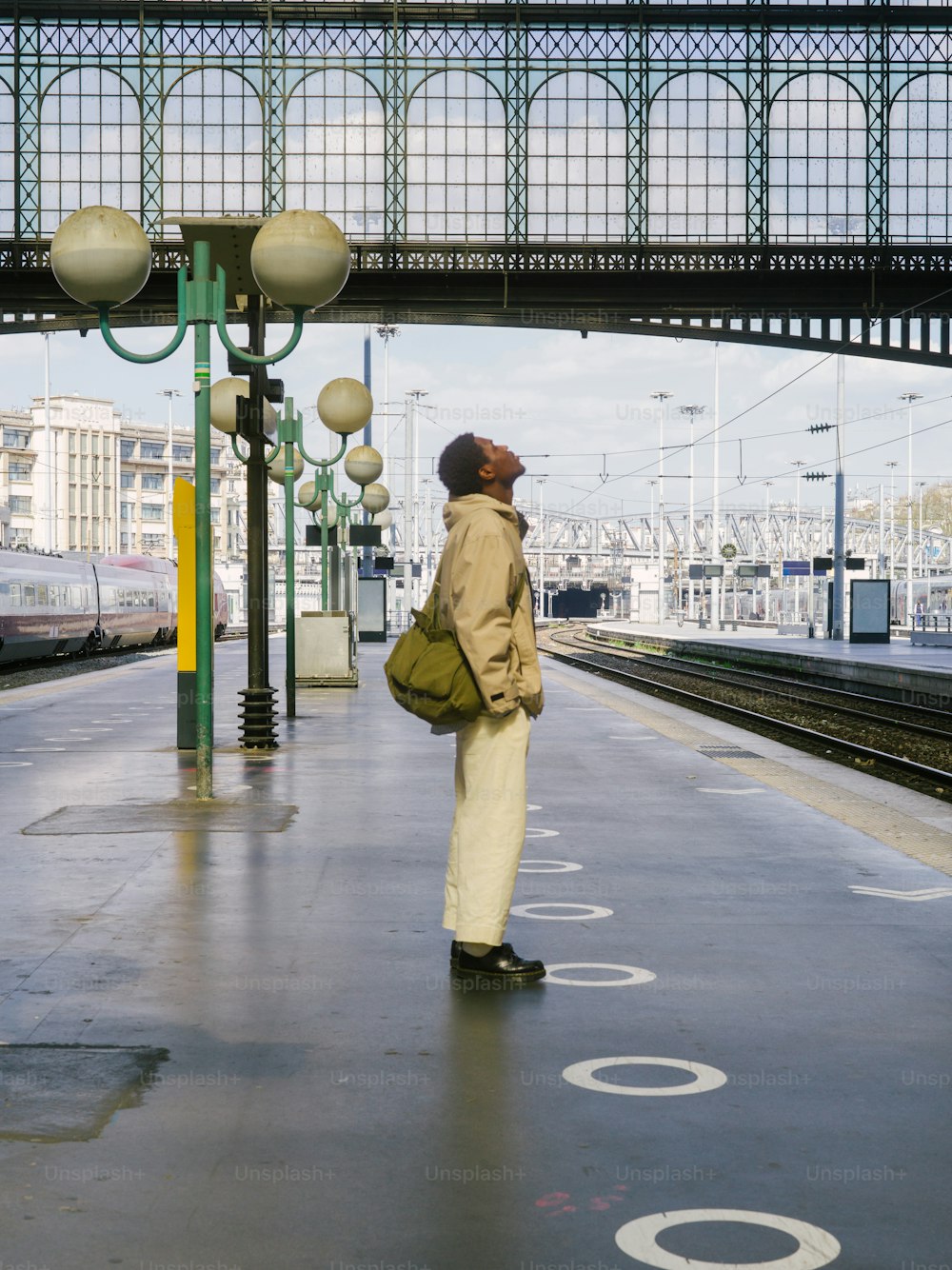 Ein Mann, der an einem Bahnhof steht und auf einen Zug wartet