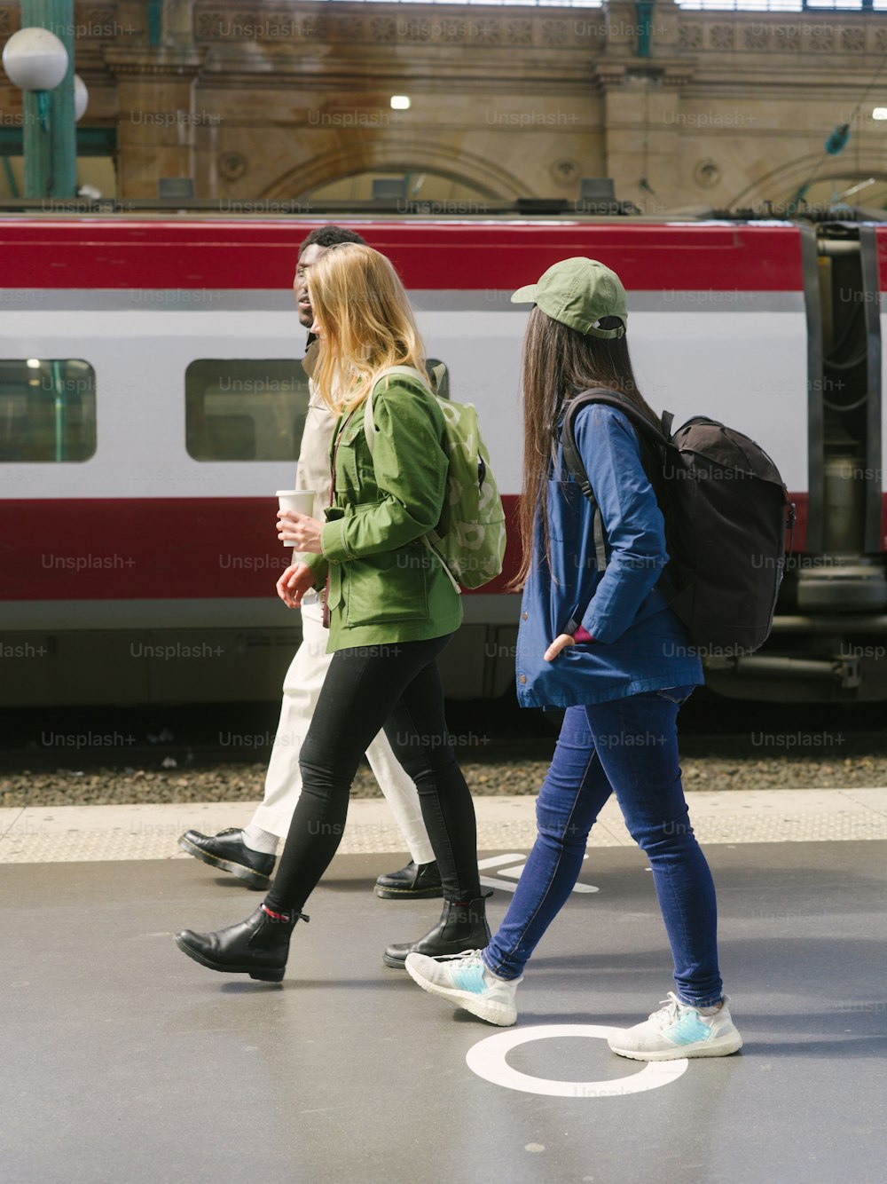 a group of people walking across a train station