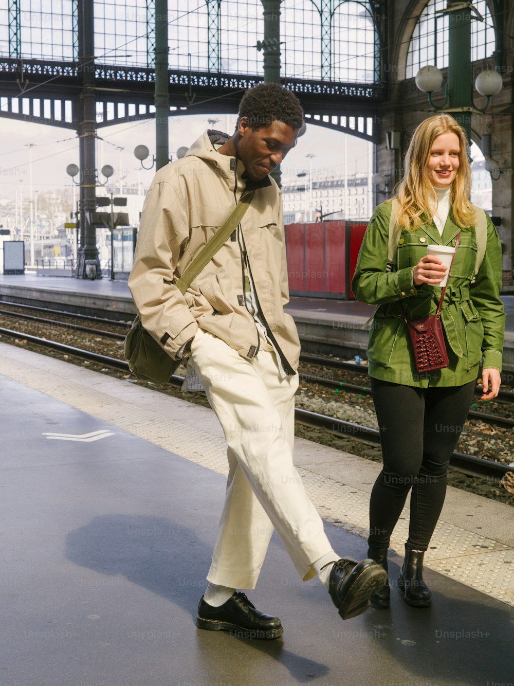 a man and a woman walking on a train platform