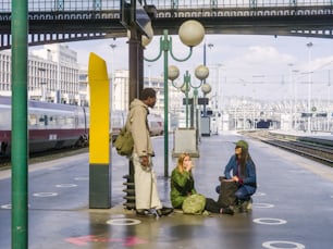 Eine Gruppe von Menschen, die an einem Bahnhof warten