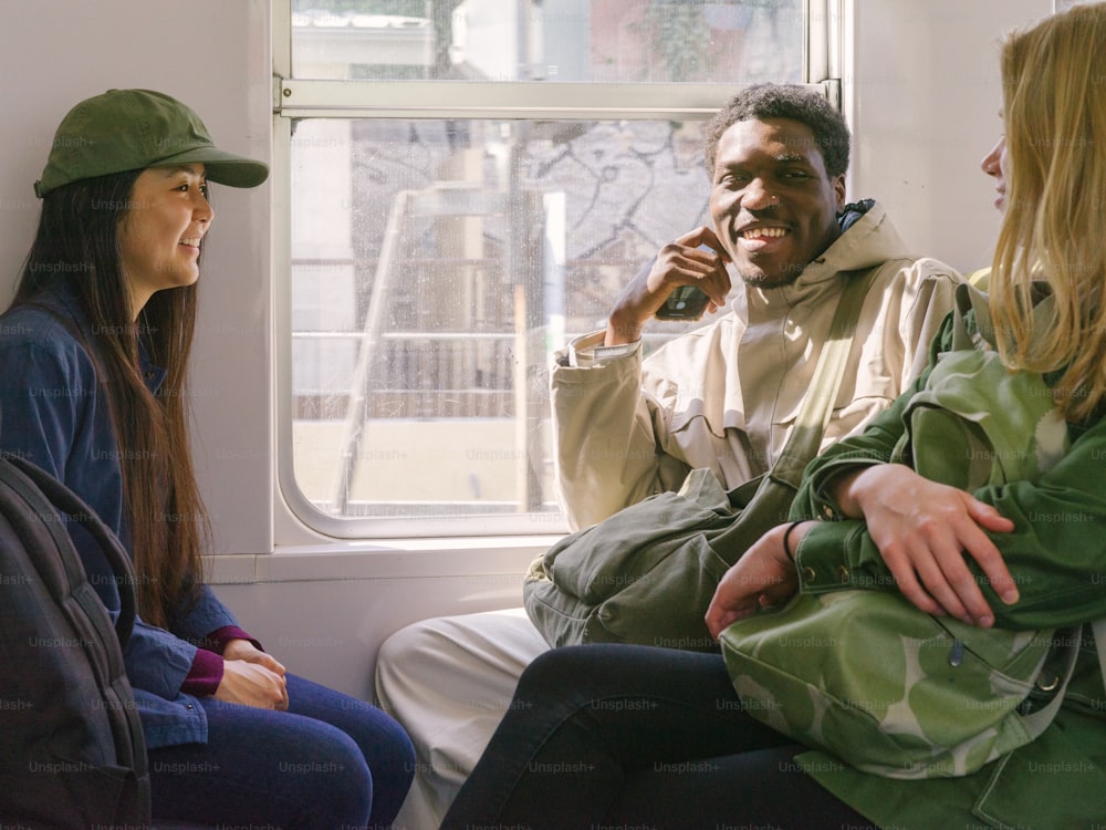 Un grupo de personas sentadas en un tren una al lado de la otra