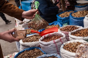 a person holding a bag of nuts in front of bags of nuts