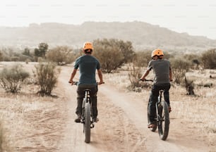 um casal de pessoas andando de bicicleta por uma estrada de terra
