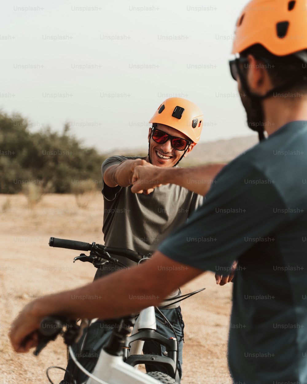 a man pointing at another man on a bike