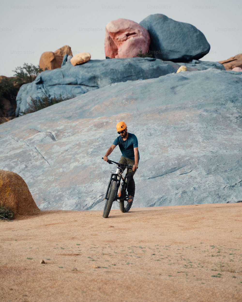 Un hombre montando en bicicleta en la cima de un campo de tierra
