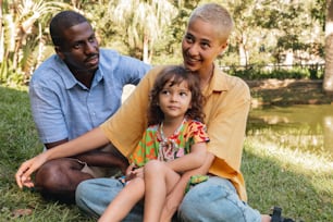 a man and a little girl sitting on the grass