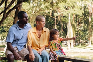 a man, woman and child are sitting on a bench