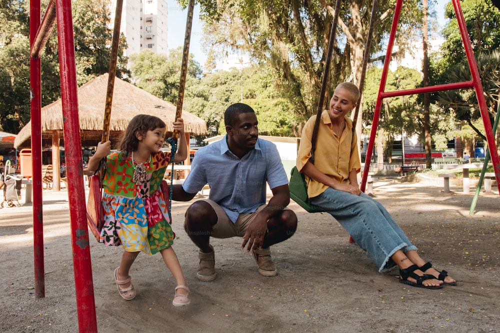 a man and two little girls sitting on a swing