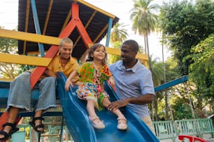 a man and two children sitting on a slide