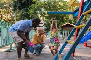 a man and two children playing on a playground